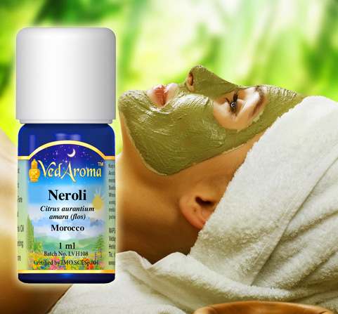 A bottle of VedAroma Neroli essential oil is shown with a photo of a woman reclining with a facial mask applied and a towel over her head.