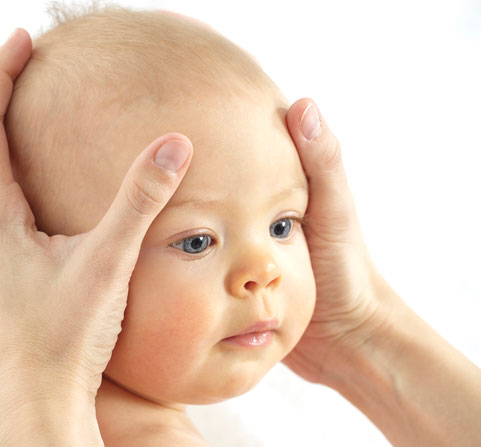An infant receiving a head massage.