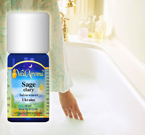 A bottle VedAroma Sage clary essential oil is shown with woman's hand reaching into a bathtub full of water.