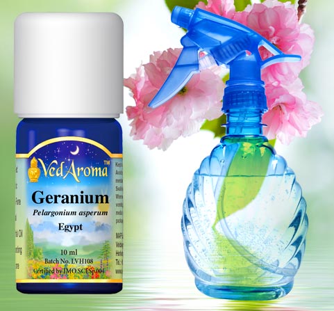 A bottle of VedAroma Geranium essential oil is shown with a photo of a a spray bottle against a background of water and flowers.