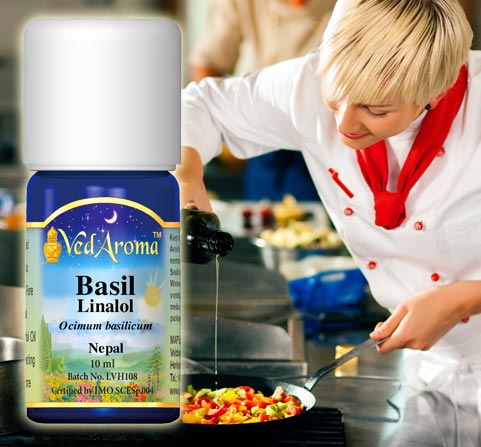 A bottle of VedAroma Basil essential oil is shown with a photo of a woman chef sautéing vegetables in the kitchen.